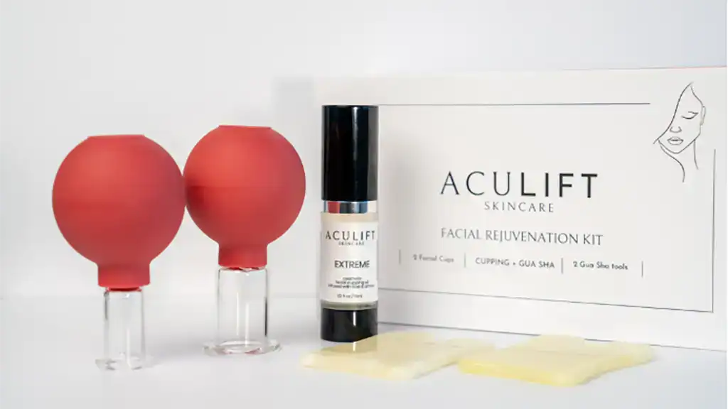 AcuLift Cups and Gua Sha tools displayed in front of box, with bottle of cupping oil